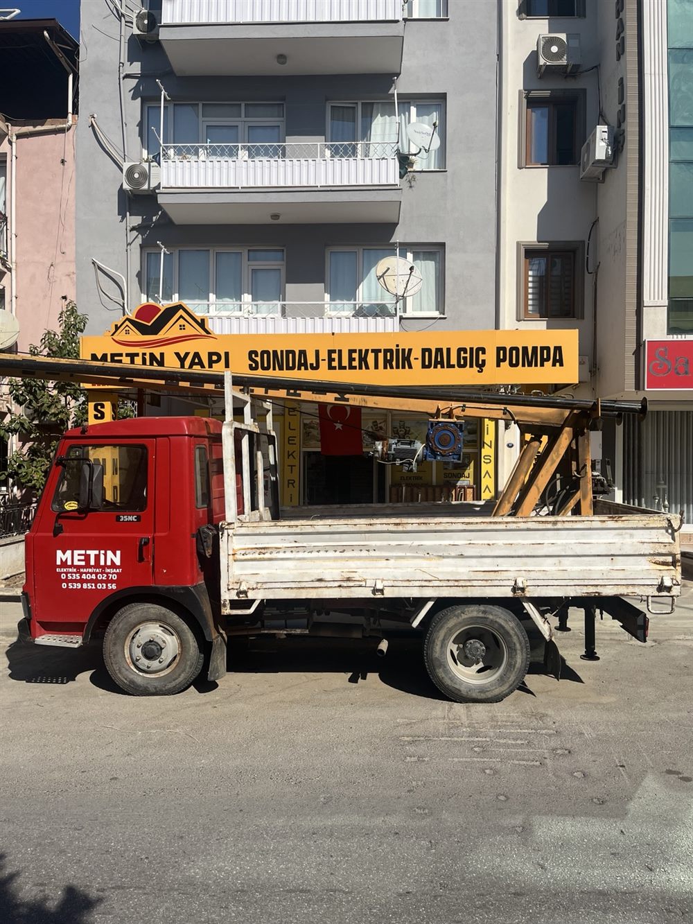Metin Yapı'nın sondaj ekipmanı taşıyan kırmızı iş aracı, işletmenin önünde